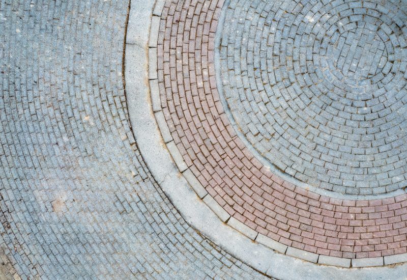 Cobblestones and bricks arranged in a circular pattern creating a visually appealing design