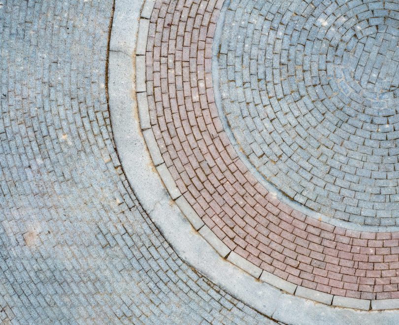 Cobblestones and bricks arranged in a circular pattern creating a visually appealing design
