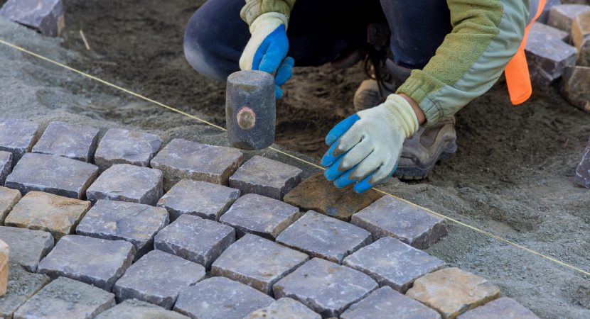Sound of workers hammering granite stones into place echoed through streets as they paved pavement with industrial cobblestones