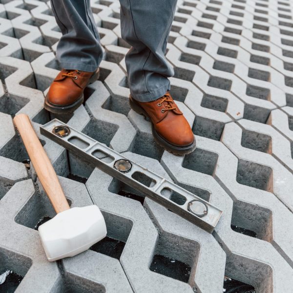 Making of floor. Young man working in uniform at construction at daytime.